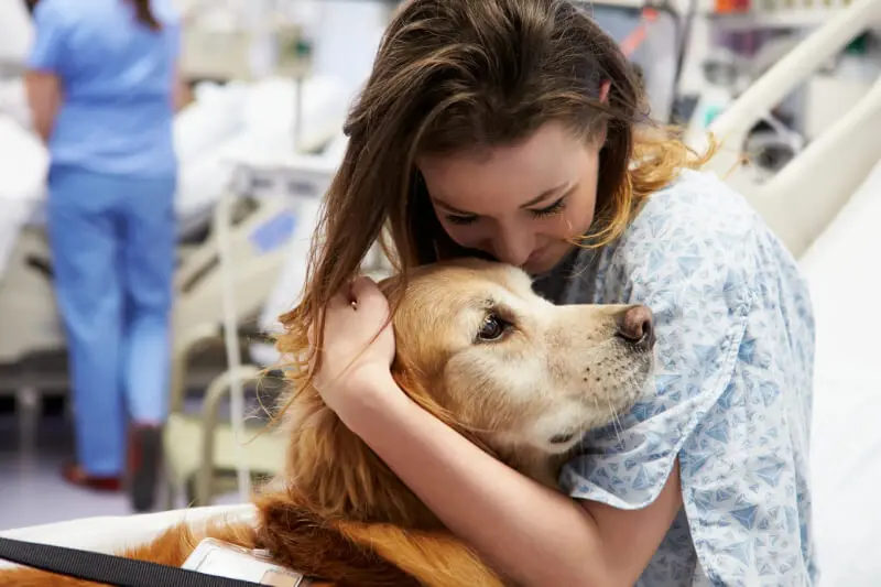 A woman hugging her dog in the hospital